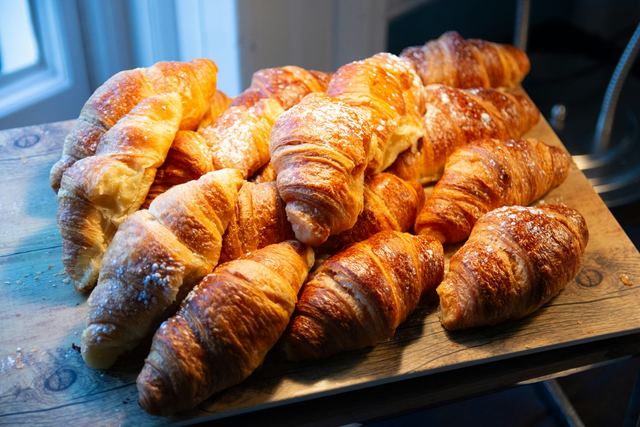 Een plank vol verse croissants met poedersuiker
